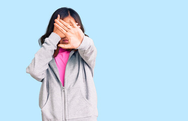 Young beautiful mixed race woman wearing casual sporty clothes covering eyes with hands and doing stop gesture with sad and fear expression. embarrassed and negative concept.