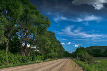 Summer landscape with green mountains and meadows, sky with clouds.