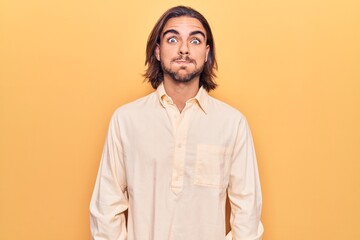 Young handsome man wearing business clothes puffing cheeks with funny face. mouth inflated with air, crazy expression.