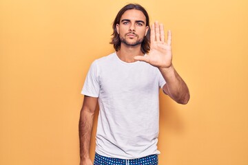 Young handsome man wearing casual clothes doing stop sing with palm of the hand. warning expression with negative and serious gesture on the face.