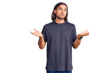 Young handsome man wearing casual clothes clueless and confused expression with arms and hands...