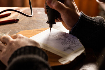 young man carving figures on wood