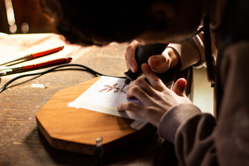 young man carving figures on wood