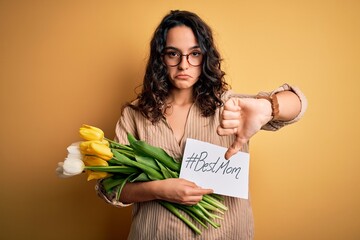 Young beautiful mom with curly hair holding flowers and card as mothers day present with angry...