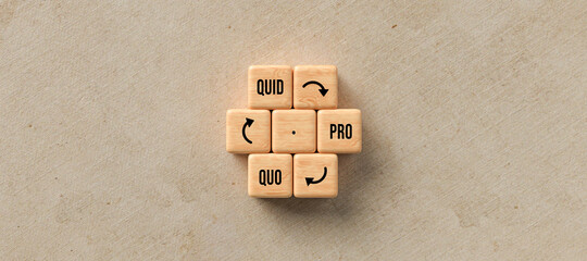 cubes with message QUID PRO QUO as a circle on paper background