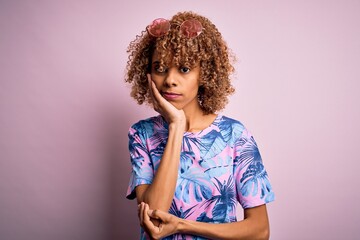 Young african american woman on vacation wearing summer t-shirt over pink background thinking looking tired and bored with depression problems with crossed arms.