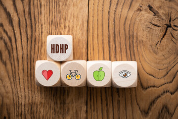 cubes with acronym HDHP for HIGH DEDUCTABLE HEALTH PLAN on wooden background