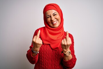 Middle age brunette woman wearing muslim traditional hijab over isolated white background Showing...
