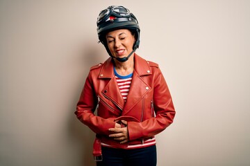 Middle age motorcyclist woman wearing motorcycle helmet and jacket over white background with hand on stomach because indigestion, painful illness feeling unwell. Ache concept.