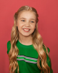 Photo of beautiful blonde girl of 8-10 years old with blue eyes, hair arranged in curls in bright...