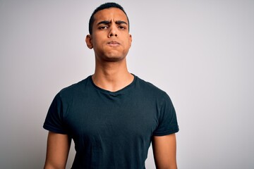 Young handsome african american man wearing casual t-shirt standing over white background puffing cheeks with funny face. Mouth inflated with air, crazy expression.