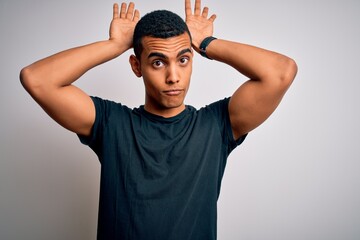 Young handsome african american man wearing casual t-shirt standing over white background Doing...