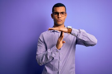 Handsome african american man wearing striped shirt and glasses over purple background Doing time...