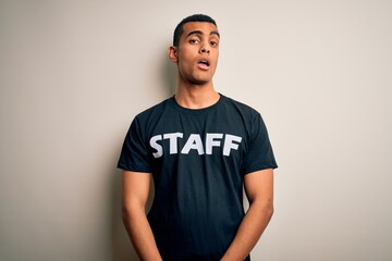 Young handsome african american worker man wearing staff uniform over white background looking...