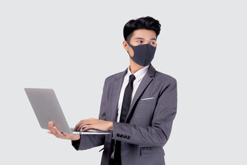 Young asian business man in face mask using laptop computer isolated on white background, quarantine and epidemic covid-19, businessman work from home for health, social distancing, new normal.