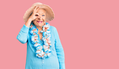Senior beautiful woman with blue eyes and grey hair wearing summer hat and hawaiian lei smiling...