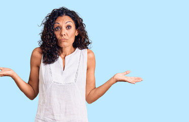 Middle age beautiful woman wearing casual sleeveless t shirt clueless and confused expression with...