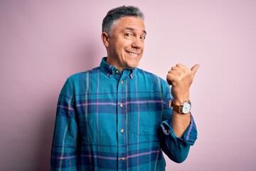 Middle age handsome grey-haired man wearing casual shirt over isolated pink background smiling with...