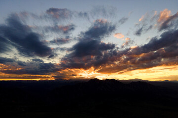 sunset over the rocky mountains with clouds