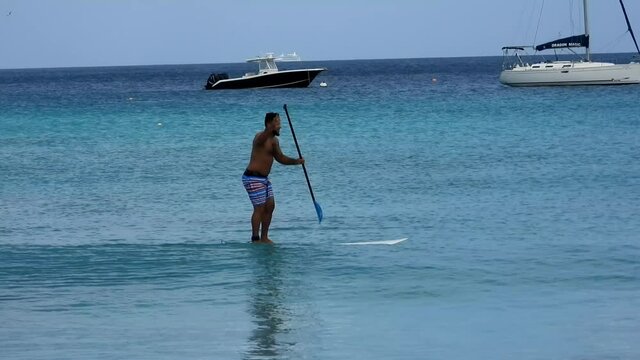 Beginner SUP paddleboarding lesson in beautiful Caribbean island in travel or tourism scene 