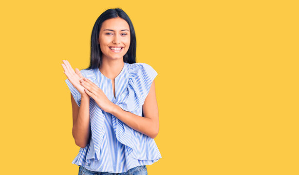 Young beautiful latin girl wearing casual clothes clapping and applauding happy and joyful, smiling proud hands together