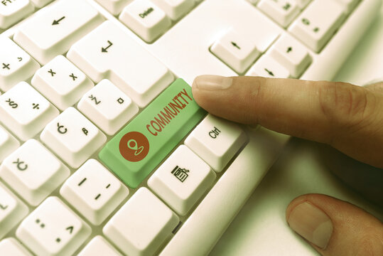 Word writing text Community. Business photo showcasing group of showing with a common characteristics living together White pc keyboard with empty note paper above white key copy space