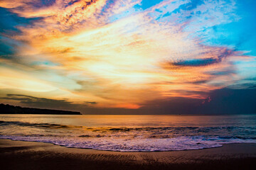 Beautiful colorful clouds on a background of blue sky and ocean on the beach of Bali island, Indonesia