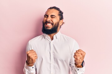 Young arab man wearing casual clothes very happy and excited doing winner gesture with arms raised, smiling and screaming for success. celebration concept.