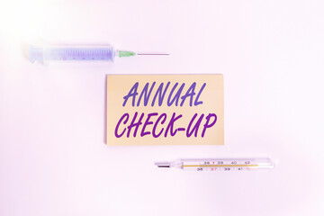 Text sign showing Annual Checkup. Business photo showcasing yearly reproductive health visit with a health care provider Set of medical equipment with notepad for health condition assessment