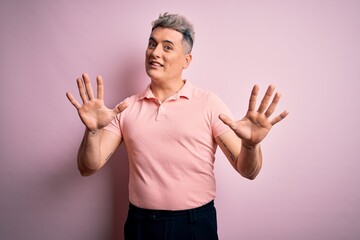 Fototapeta premium Young handsome modern man wearing casual pink t-shirt over isolated background afraid and terrified with fear expression stop gesture with hands, shouting in shock. Panic concept.