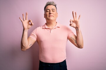 Young handsome modern man wearing casual pink t-shirt over isolated background relax and smiling with eyes closed doing meditation gesture with fingers. Yoga concept.