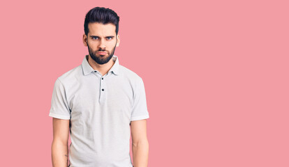 Young handsome man with beard wearing casual polo skeptic and nervous, frowning upset because of problem. negative person.