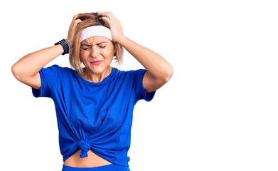 Young blonde woman wearing sportswear suffering from headache desperate and stressed because pain and migraine. hands on head.