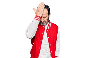 Middle age handsome man wearing baseball jacket over isolated white background surprised with hand on head for mistake, remember error. Forgot, bad memory concept.