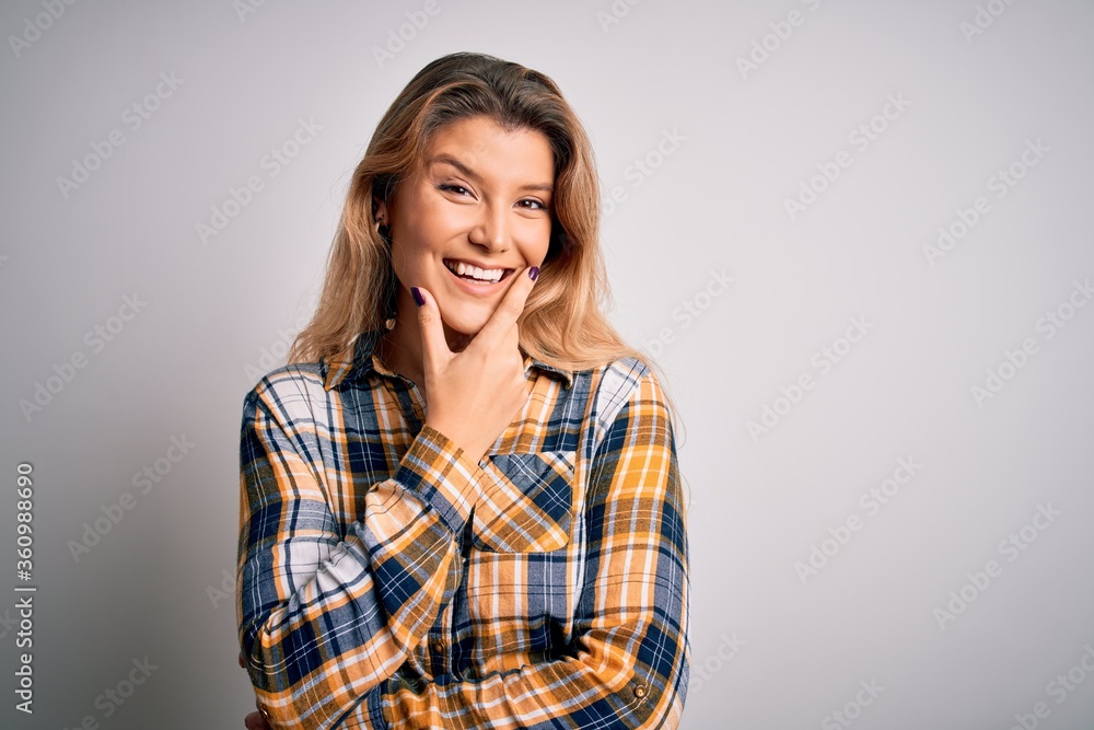 Canvas Prints Young beautiful blonde woman wearing casual shirt standing over isolated white background looking confident at the camera smiling with crossed arms and hand raised on chin. Thinking positive.