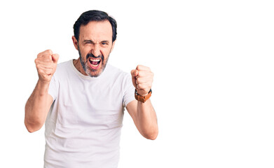 Middle age handsome man wearing casual t-shirt angry and mad raising fists frustrated and furious while shouting with anger. rage and aggressive concept.