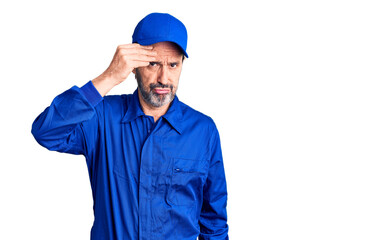 Middle age handsome man wearing mechanic uniform worried and stressed about a problem with hand on...