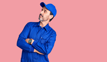 Middle age handsome man wearing mechanic uniform looking to the side with arms crossed convinced and confident