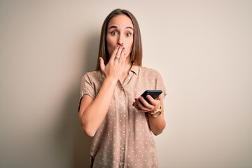 Young beautiful woman having conversation using smartphone looking at the mobile cover mouth with...