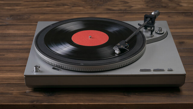 A Red Vinyl Record Player On A Wooden Table.