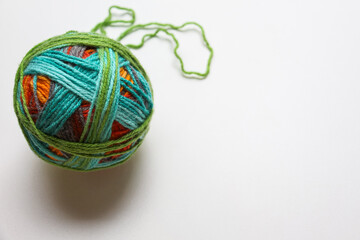 Skein of woolen yarn for needlework. Multi-colored yarn for knitting stylish and warm clothes for the family. The ball resembles a sphere with a bright texture.