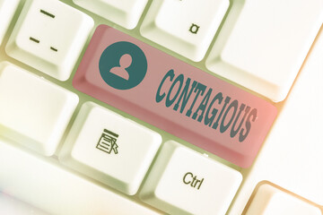 Handwriting text writing Contagious. Conceptual photo transmissible by direct or indirect contact with infected an individual White pc keyboard with empty note paper above white key copy space