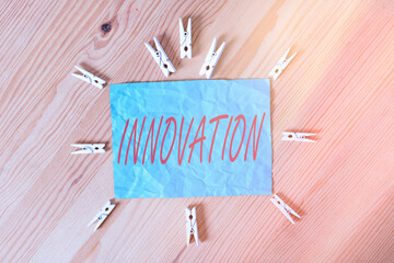 Word writing text Innovation. Business photo showcasing new idea creative ideas fresh imaginations in the tool form process Colored clothespin papers empty reminder wooden floor background office