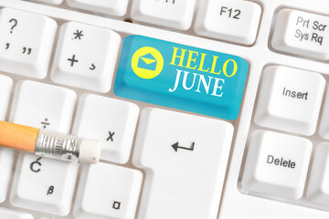 Writing note showing Hello June. Business concept for a new month to plan your activities for fun and adventures White pc keyboard with empty note paper above white key copy space