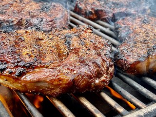 closeup of a ribeye steak cooking on a grill
