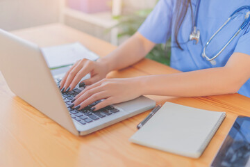 Isolation professional female Asian doctor working on laptop , writing a coronavirus positive patient a prescription hydroxychloroquine sulfate tablets.pandemic infection outbreak Coronavirus Medical