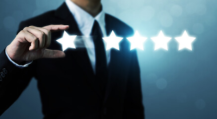 Businessman hand holding five star symbol to increase rating of company concept