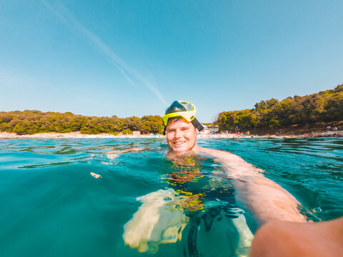 young smiling man taking selfie in snorkeling mask