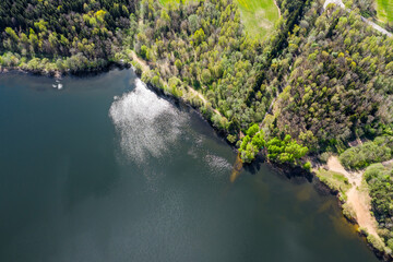 Naklejka premium aerial view of forest and blue lake with clouds reflection. Vyacha lake, Belarus.
