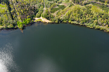 rural landscape with green forest near lake on summer day. coastline view from above. aerial panoramic view.
